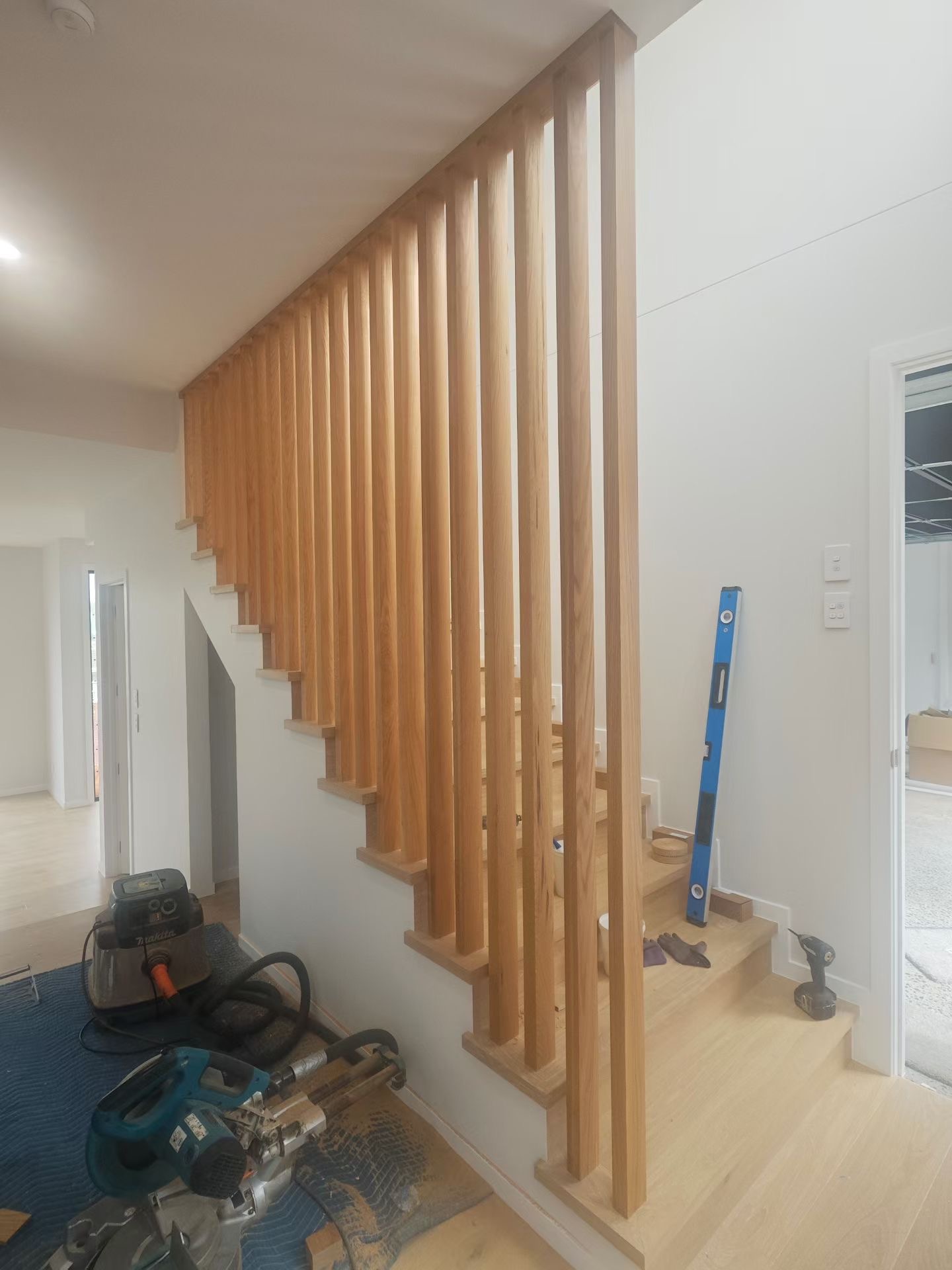 Floor-to-ceiling slat screen defining the stairwell