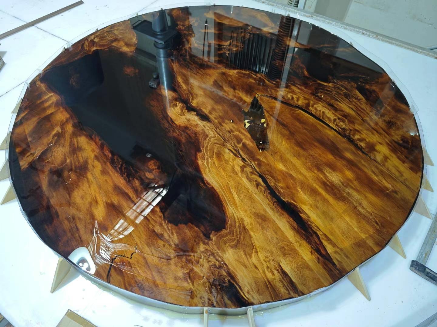 Round epoxy resin table with rich timber and dark resin