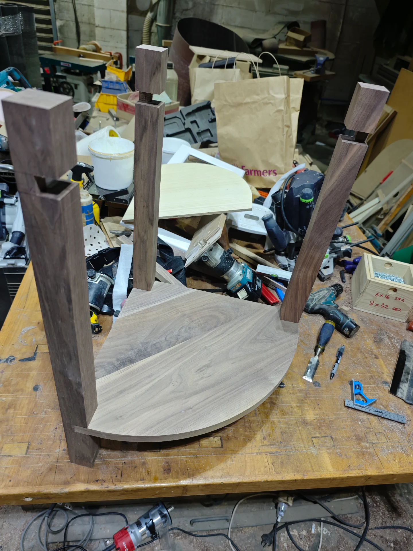 Black walnut corner table parts being dry fitted in the Auckland workshop
