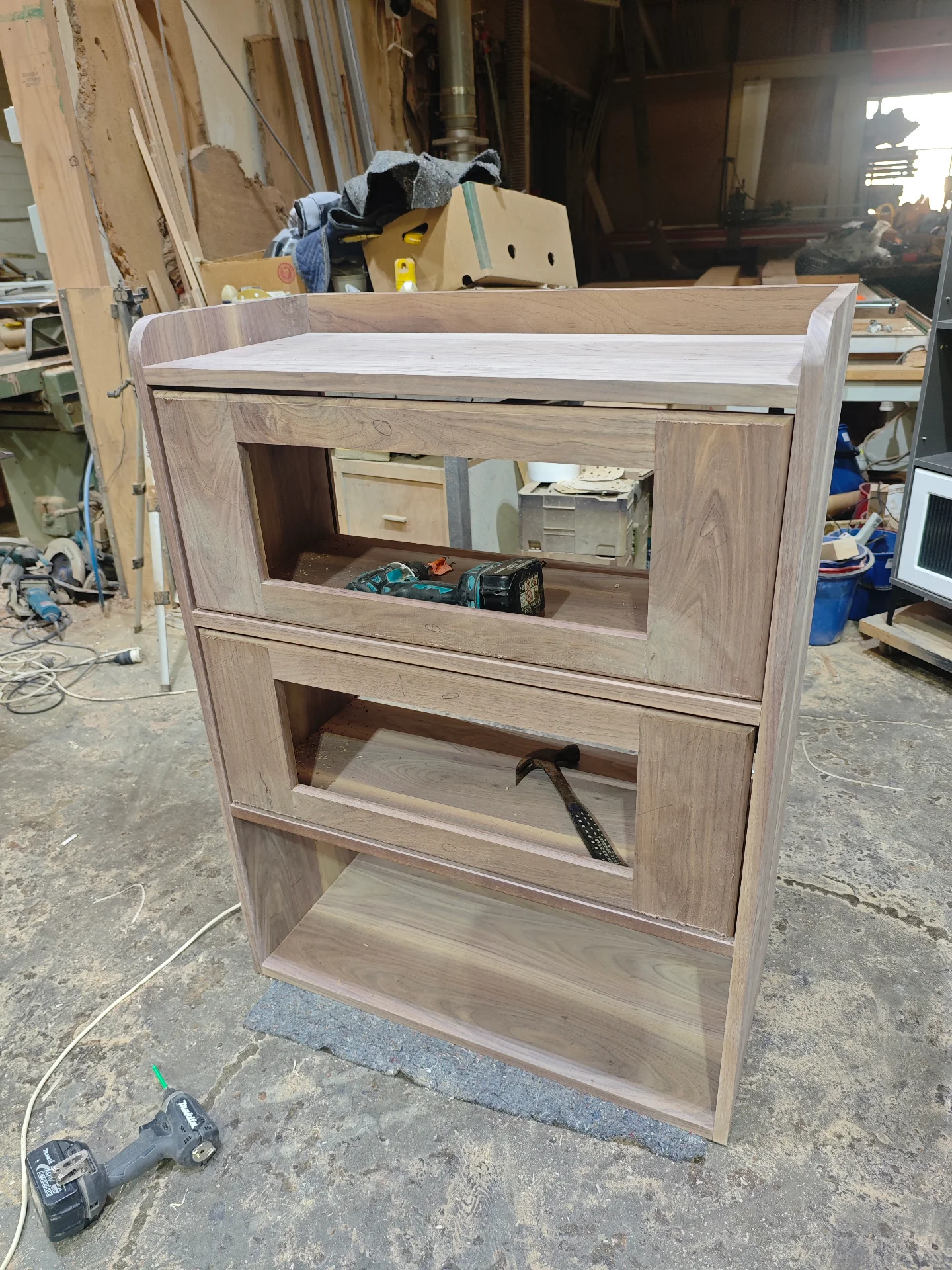 Unfinished walnut storage cabinet showing drawer and door openings