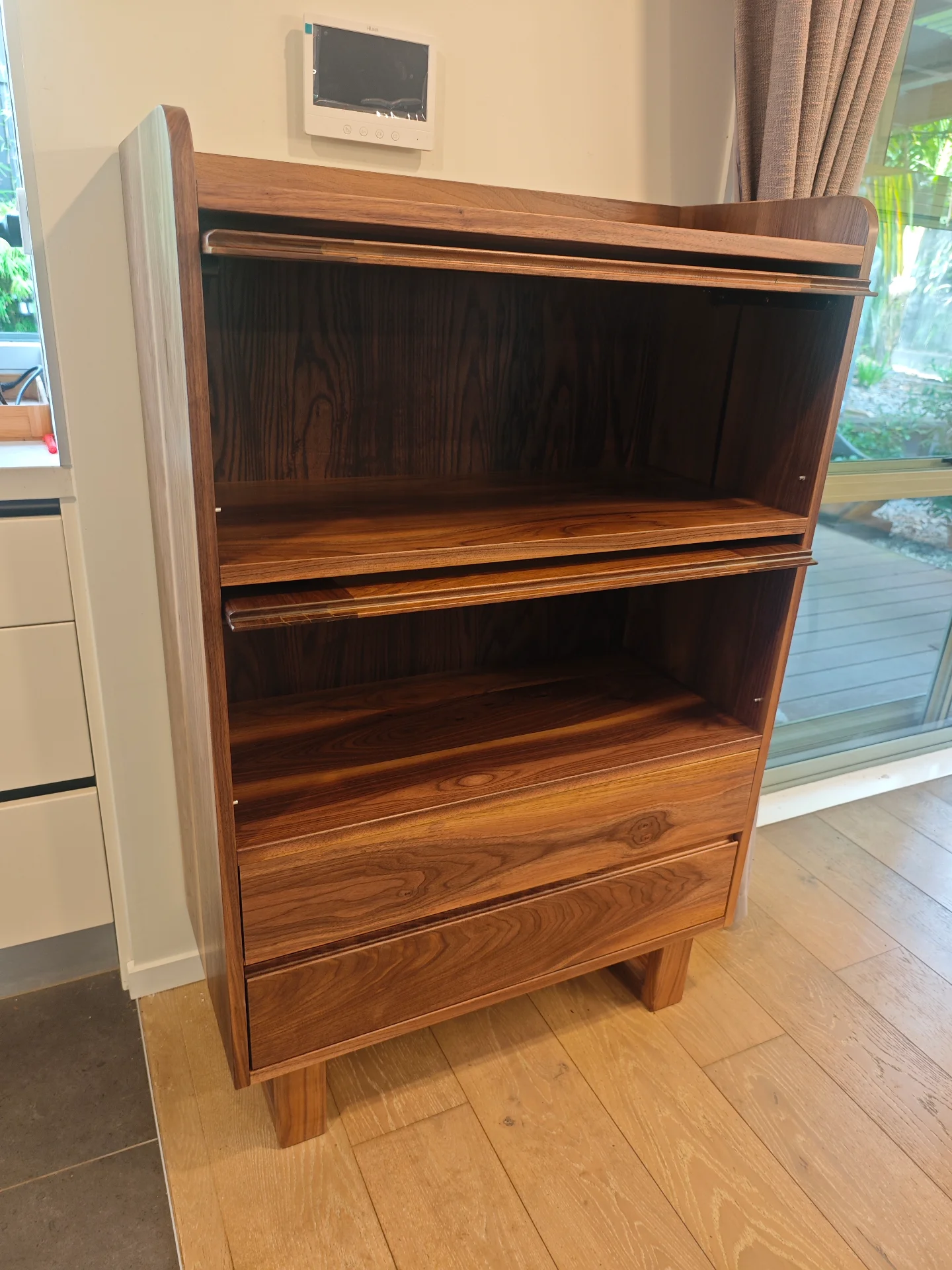 Finished black walnut cabinet with upper doors open and lower storage visible